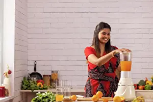 Positive Emotion Prints: Woman making orange juice in kitchen