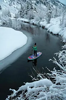 Sports Equipment Prints: Woman paddleboarding on river during winter