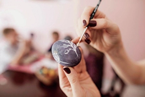 35 40 Prints: Woman painting Easter egg at home with children in background