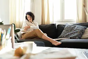 Talent Prints: Woman with pillow on sofa near table with brushes and laptop
