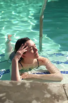 Blue Water Prints: Woman relaxing in a pool, basking in sunlight with eyes closed