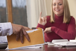 Bill Prints: Woman signing the word Insurance in American Sign Language while communicating with a man