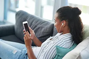 Video Prints: Woman, smartphone and home on couch with earphones