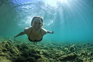 Model Release Prints: A woman smiles as she swims in the clear blue waters of the Clutha River near Wanaka