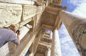 Inscription Prints: Woman taking upwards photograph of pillars at entrance to Library of Celcus Ephesus TURKEY Ephesus