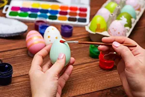 Hunt Prints: A woman with a tassel paints Easter eggs. Preparing decorations for Easter