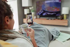 Lockdown Prints: Woman with tea video chatting with parents on smart phone screen