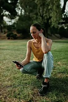 Typing Prints: Woman using mobile phone crouching at park