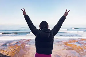 Hike Prints: Woman wearing gym clothes looking at the ocean from the cliffs