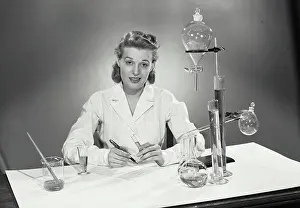 Experiment Prints: Woman wearing lab coat sitting with laboratory scientific equipment