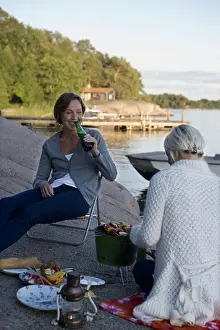 Seas Prints: Two women having a picnic by the sea in the archipelago of Stockholm, Sweden