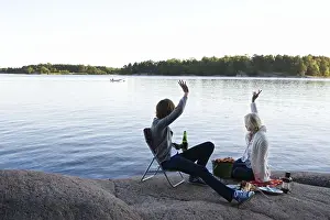 Holidays Prints: Two women having a picnic by the sea in the archipelago of Stockholm, Sweden