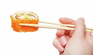 Essen Prints: wood chopsticks holds california ebi roll isolated female hand with wooden chopsticks holds california ebi sushi roll