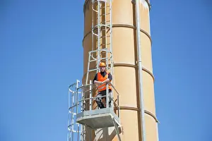 Maintenance Prints: Worker inspecting industrial equipment against a clear blue sky