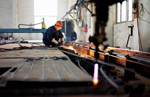 Business And Occupation Prints: Worker using equipment in crane manufacturing facility, China