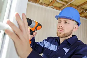 Mounting Prints: workman using cordless drill while installing pvc windows
