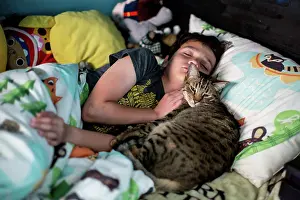 Bedroom Prints: Ten year old boy sleeps while his tabby cat snuggles him