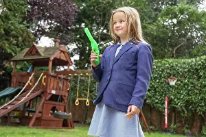 Smart Prints: A ten year old girl in school uniform holding a water pistol