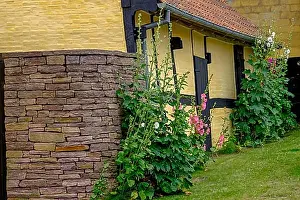 Exterior Photographs Prints: Yellow house with stone facade and flowers growing along the house