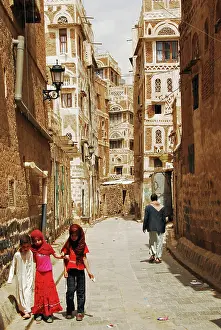 Residential Structure Prints: Yemen, Sanaa, three small children walking along narrow lane amid old buildings