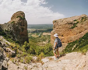 36 39 Years Old Prints: A young athletic woman stops at viewpoint along the Riglos rock track