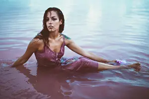 Attractive Prints: Young beautiful and fatal Hispanic woman with curly hair in wet summer dress sitting in sea water