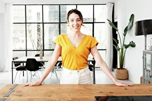 Beverage Prints: Young beautiful modern woman stands near table on kitchen at home