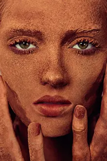 Temptation Prints: Young beautiful woman with chocolate powder on face touching skin and looking at camera