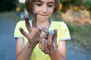 Soft Focus Prints: Young boy holding murbel tay in his dirty hands