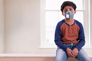 Horizontal Image Prints: Young boy looking tired of wearing a pollution mask at home. (Children)