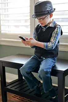 Glass Material Prints: Young boy playing games on a cellphone