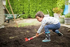 Hard Work Prints: Young boy shoveling dirt, helping dad with landscape project