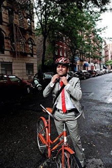 Adjusting Prints: Young businessman adjusting cycle helmet in street