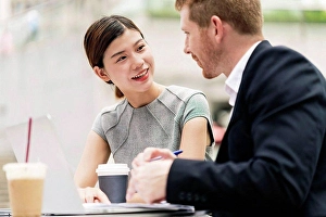 Cafeteria Prints: Young businessman and woman having discussion at sidewalk cafe