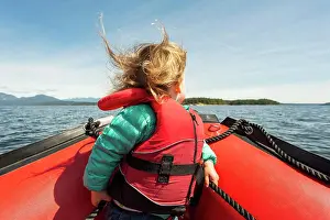Parenting Prints: Young child sits on bow of rubber raft in big sunny bay