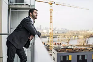 Balcony Prints: Young contractor standing with confidence on condo balcony