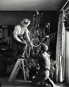 Streamer Prints: Young couple decorating a Christmas tree