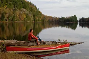 Young couple enjoy quite evening beside canoe on Oxtongue Lake, Muskoka, Ontario, Canada