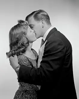 Wristwatch Prints: Young couple kissing, studio shot