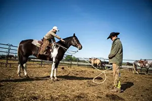Skilled Prints: Young cowboy lassoing his father for practice