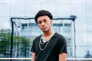 Wear Prints: From below of young curly haired African American teenage guy in black t shirt