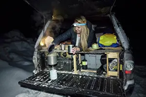 Tent Prints: Young female making tea in back of truck while winter camping