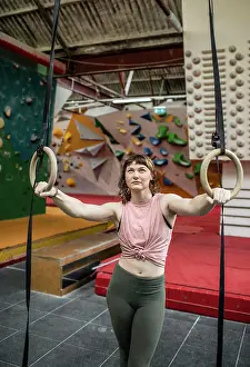 Aspirations Prints: Young female rock climber training at gymnastics rings