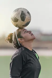 Balance Prints: Young female soccer player balancing a ball on her head