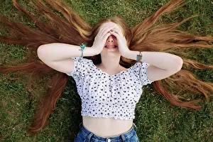 Denim Prints: Young ginger teen girl smiling and covering her eyes with hands