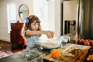 Prepare Prints: Young girl cracking egg into bowl of peach muffin batter