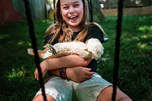 Generation Z Prints: Young girl laughing while swinging with her pet chicken