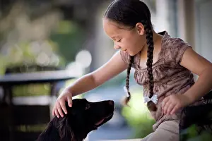 Relationships Prints: Young girl patting a dog on a porch