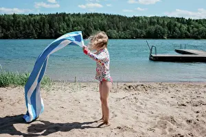 Parenting Prints: young girl shaking her towel at the beach in Sweden
