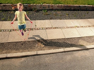 Only One Prints: Young girl skipping on sidewalk